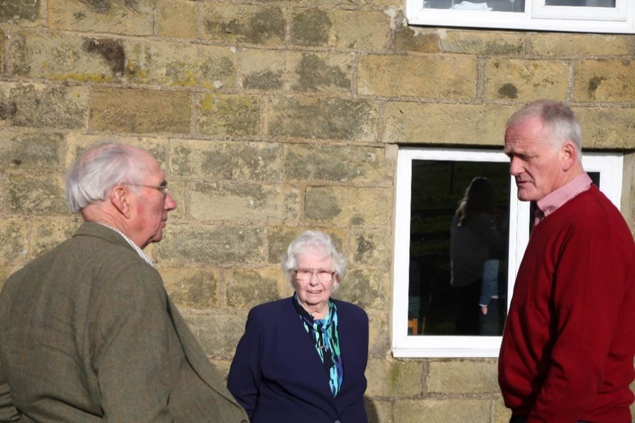 A group of old people talking
Description automatically generated